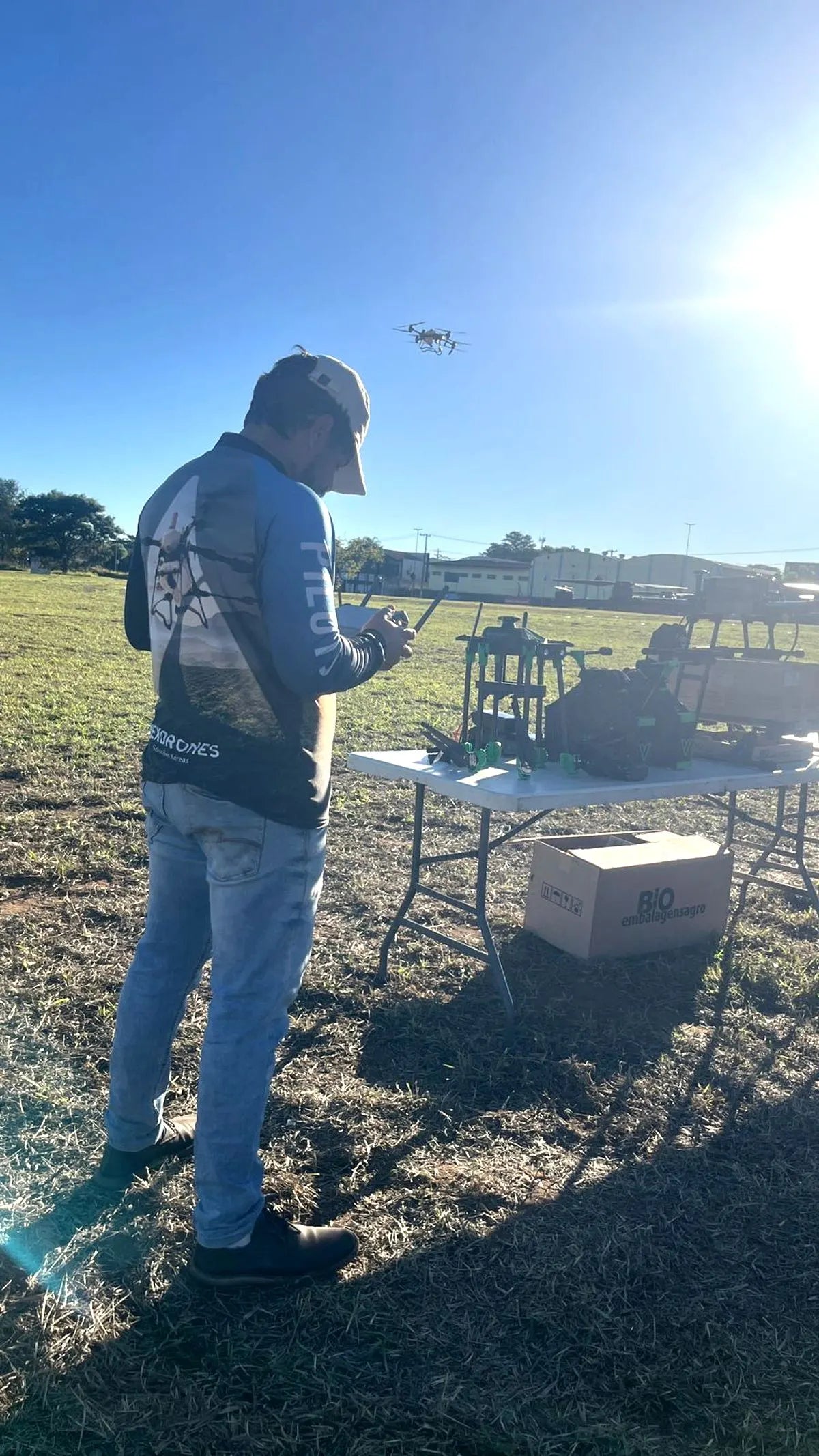 Egresso da formação operando um drone agrícola em campo