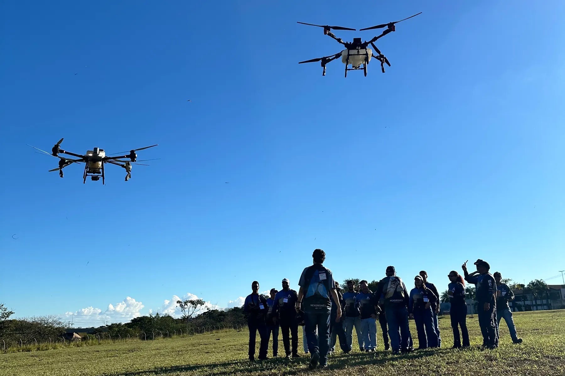 Turma da Imersão Piloto PRO acompanhando dois drones agrícolas em operação