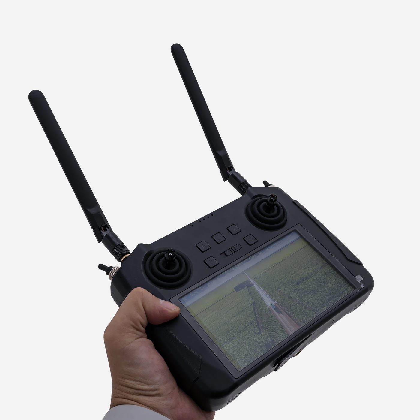 Controle Smart do NX6 na mão do operador, com a tela ligada mostrando a imagem aérea da lavoura
